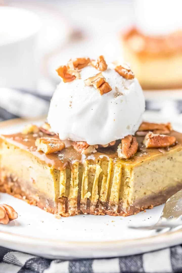 Pumpkin Cheesecake Bar on a plate topped with a scoop of vanilla ice cream