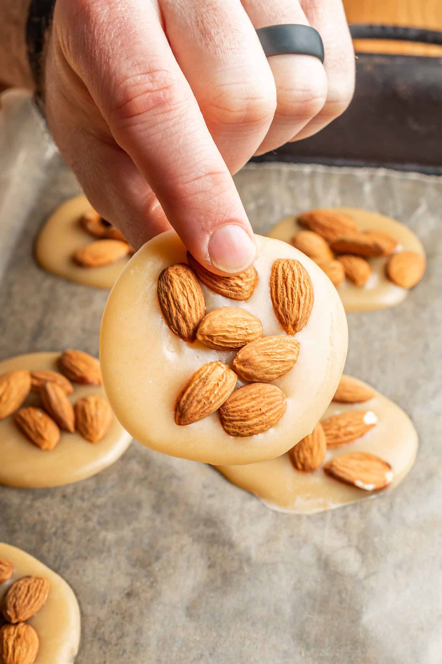 caramel almond disk being held up by a hand