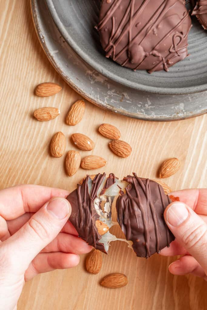 Keto Turtle Candy being torn apart so the caramel pull is visible