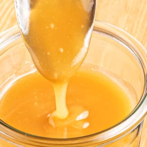 Sugar Free Caramel Sauce in a weck jar with a spoon drizzling some in