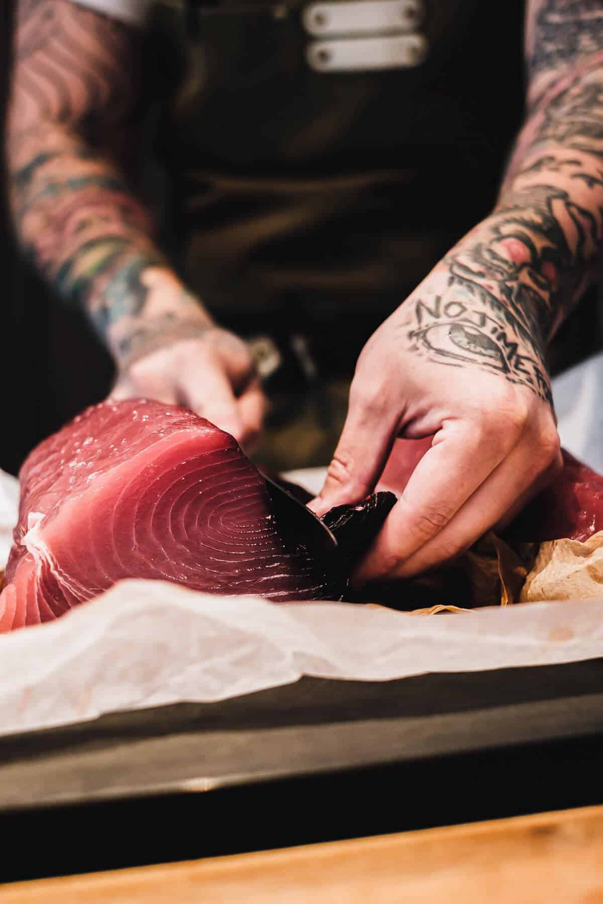 a chef cutting a piece of tuna