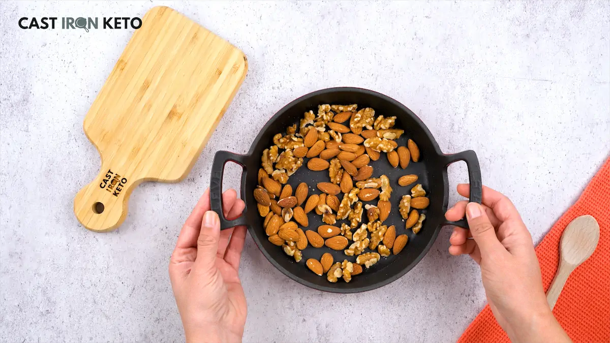 Roasted almonds and walnuts in a small cast iron skillet.