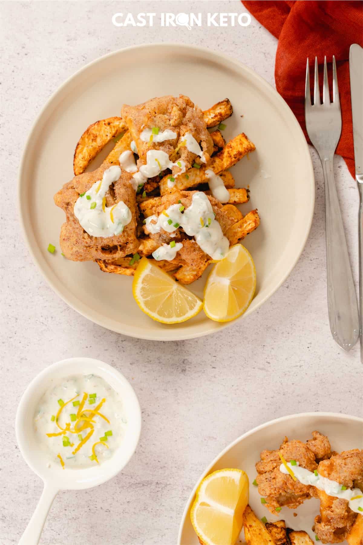 a white plate topped with keto-friendly fish and chips next to a bowl of dip.