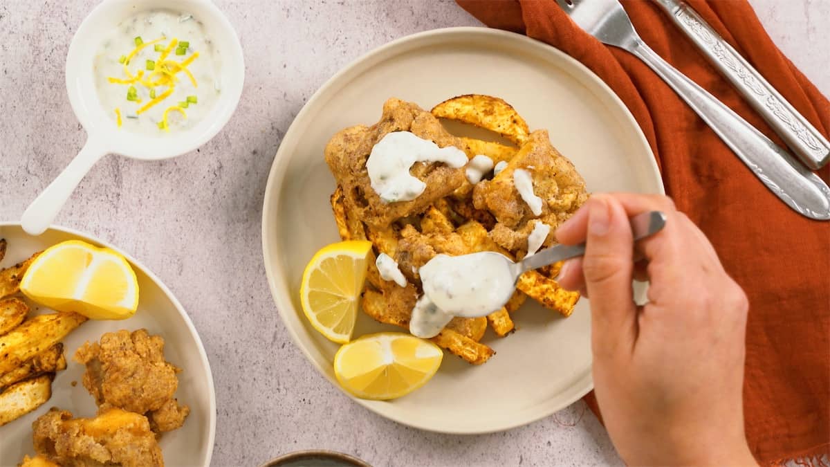 a plate of keto-friendly fish and chips with a side of lemon wedges.