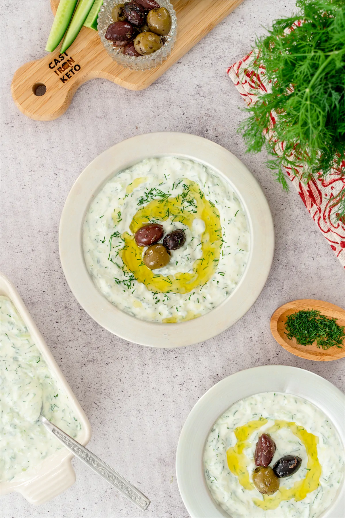 A serving of homemade keto tzatziki featuring olives, beautifully plated on a white surface.