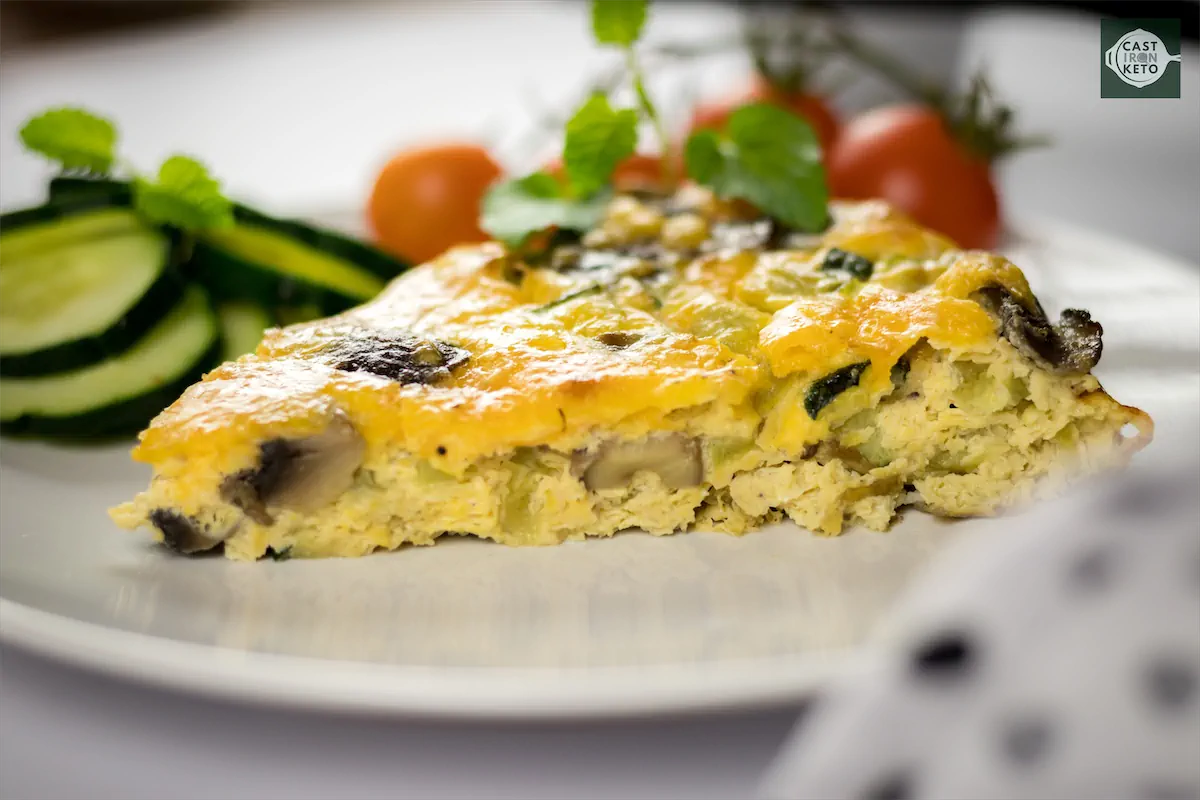 Triangular piece of keto vegetable frittata served on a plate.