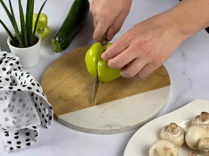 Bell pepper being cut by a sharp knife.