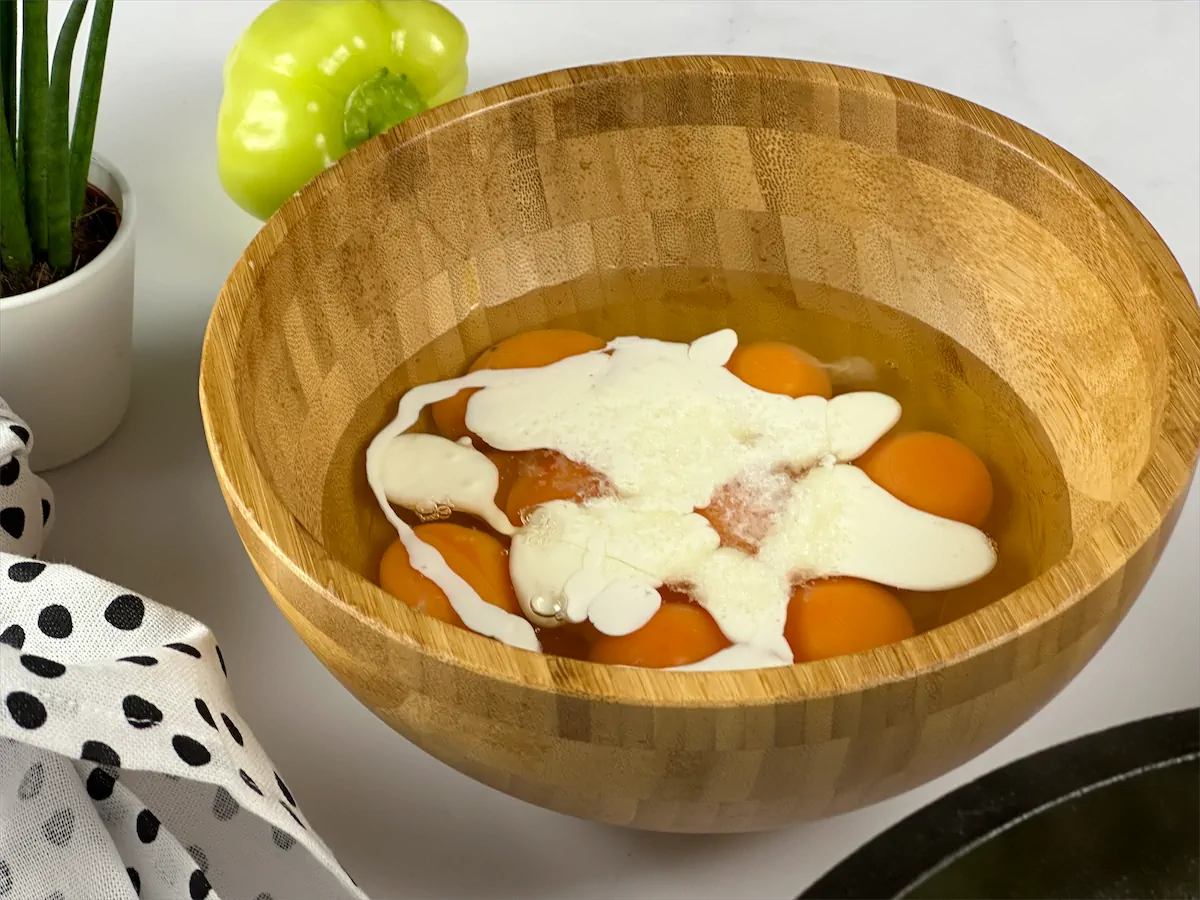 Eggs, coconut cream, and salt collected in a bowl.