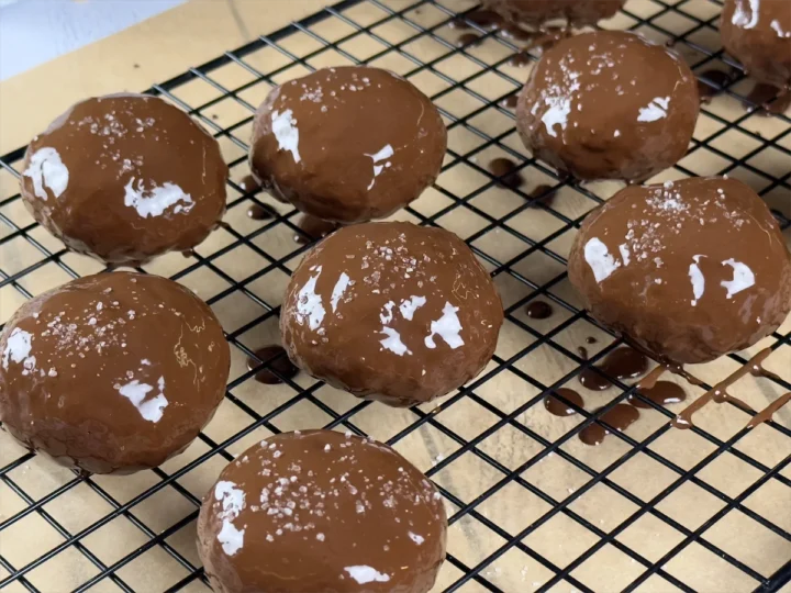 Final arrangement of chocolate-coated, sea salt-sprinkled cookies on a baking sheet.