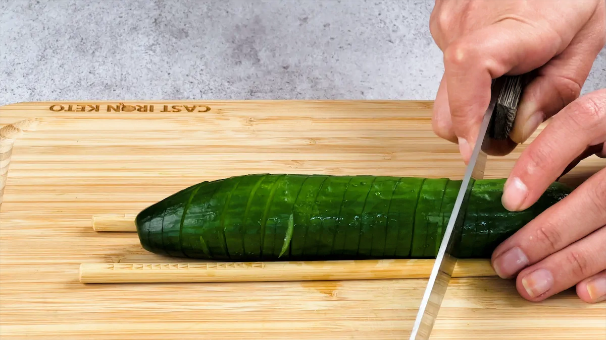 Cutting cucumber with a knife.