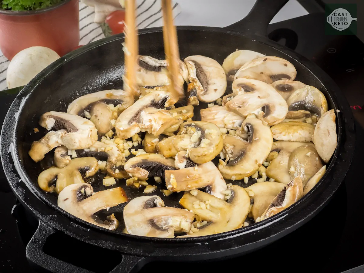 Cooking mushrooms and garlic in a skillet.