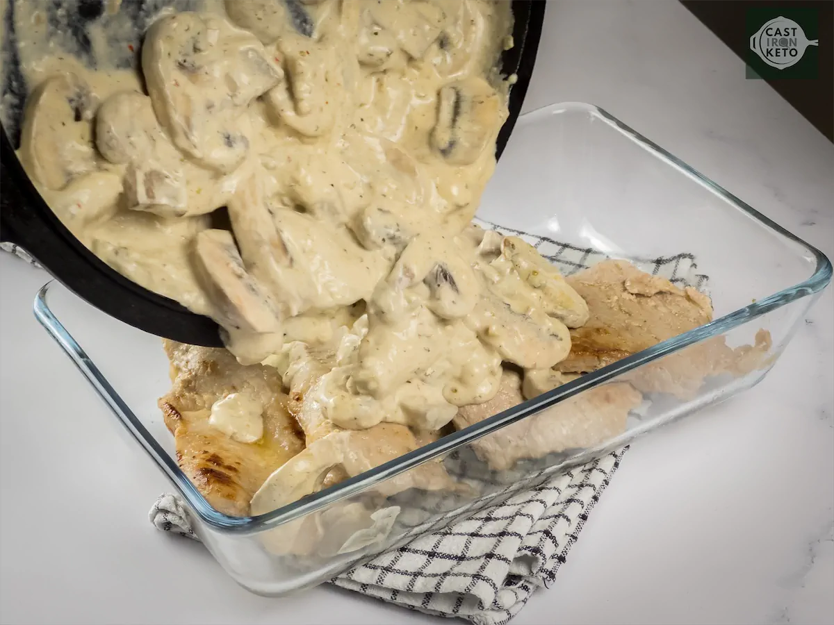 Pour cream sauce with mushrooms over pork chops in a baking dish.
