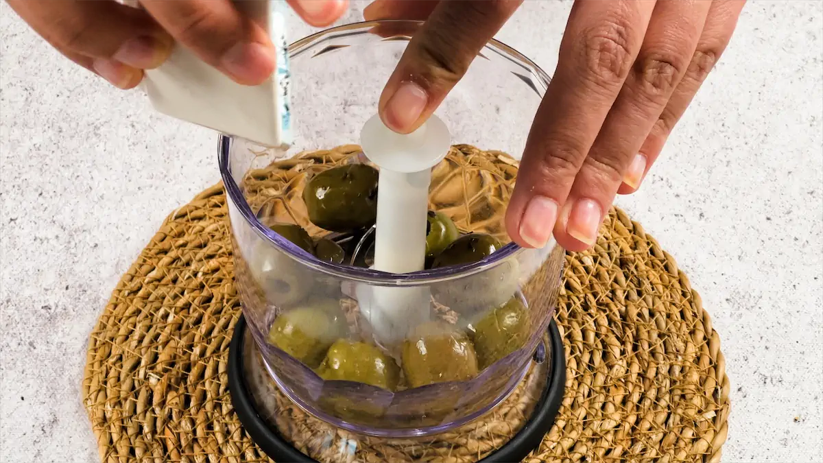 Adding olives to mixture,