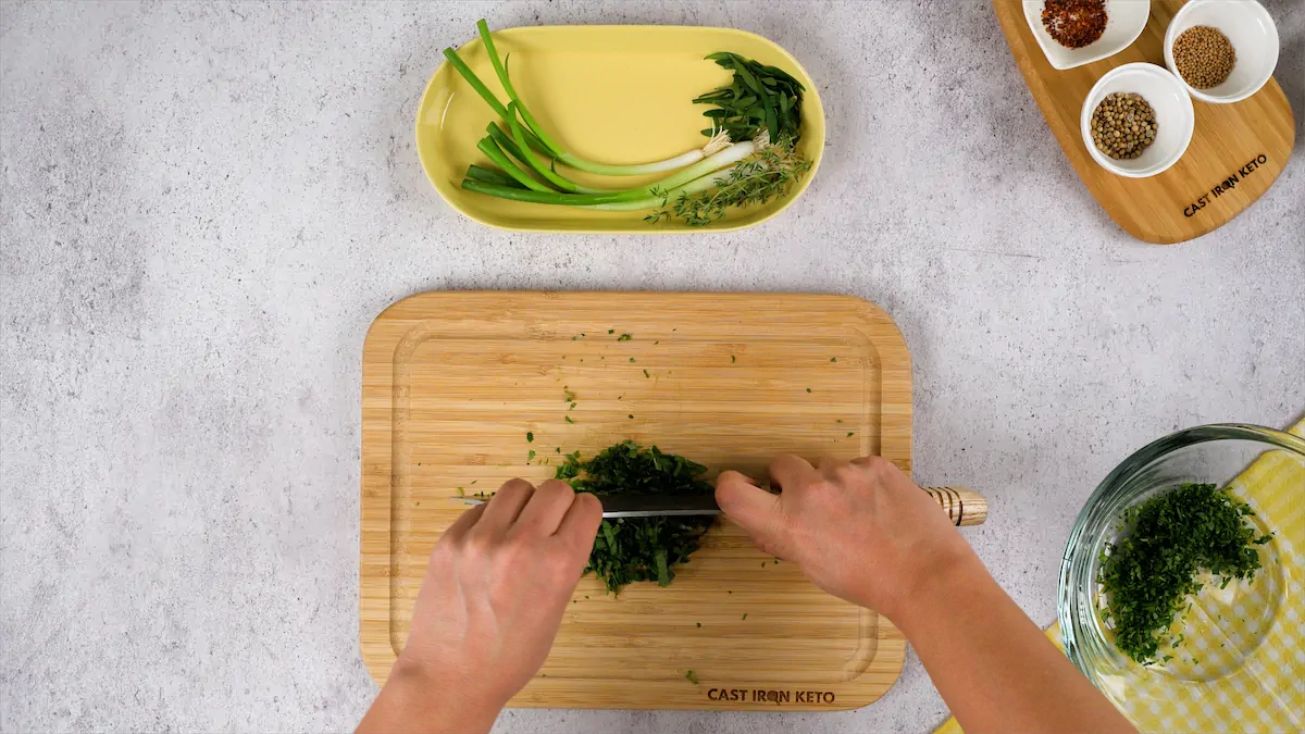 Chopping herbs on a chopping board.