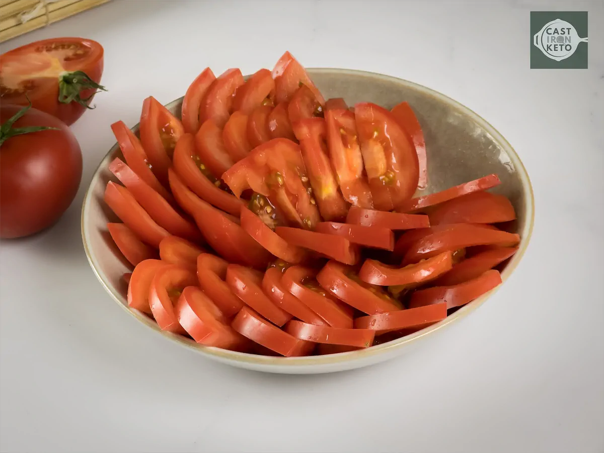 A bowl of thinly sliced tomatoes.