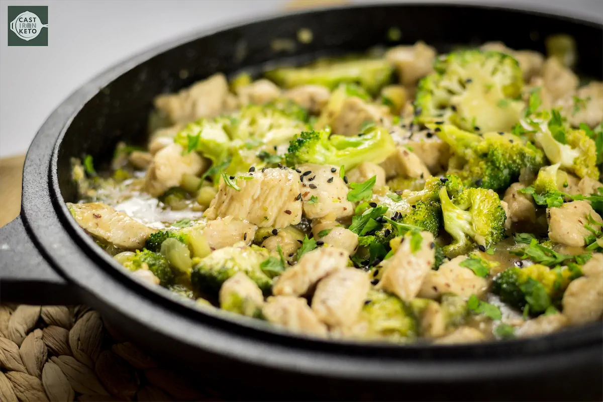 Healthy low-carb chicken stir fry loaded with broccoli and bell peppers, presented in a cast iron skillet.