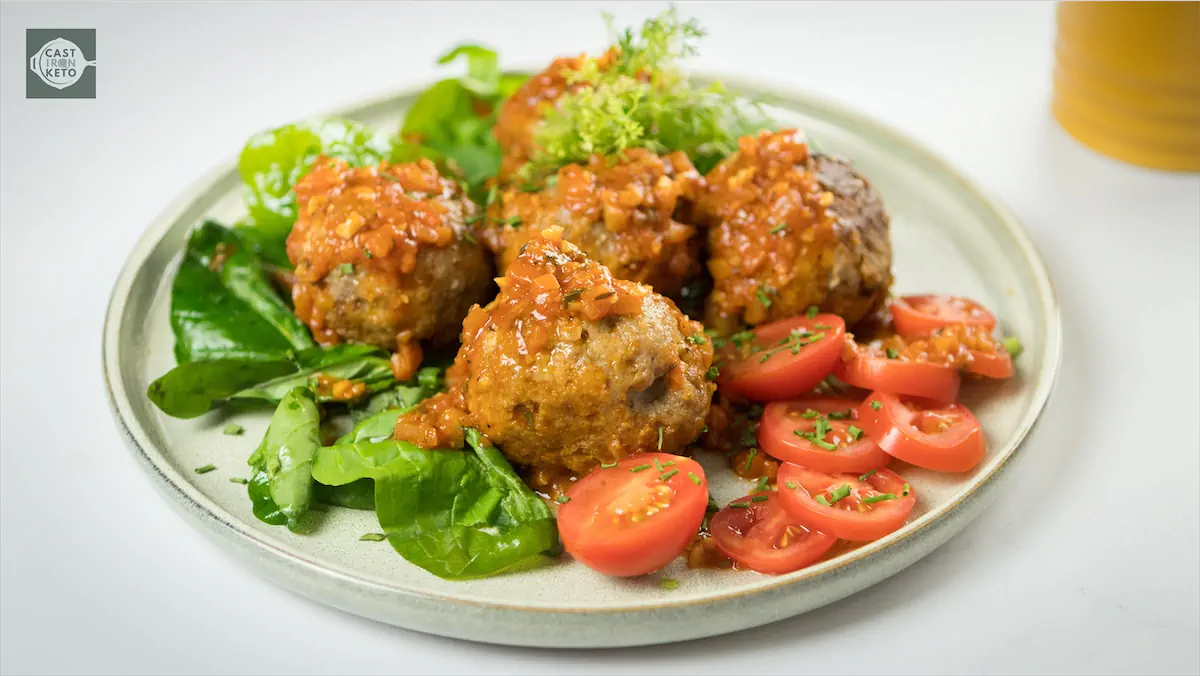 Old school Italian meatballs recipe on a plate served with sliced tomatoes.