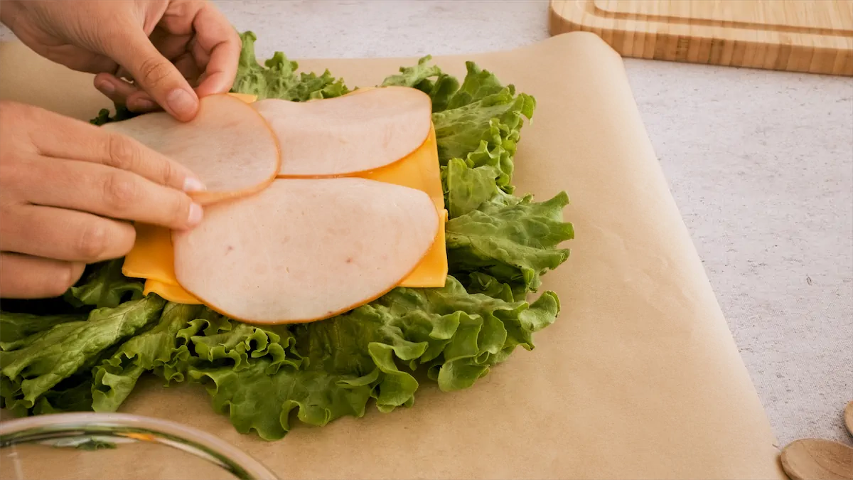 Placing cheese and turkey slices on top of lettuce leaves.