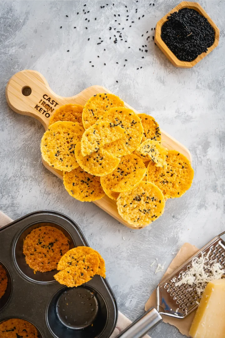 Low carb parmesan crisps on wooden serving tray.