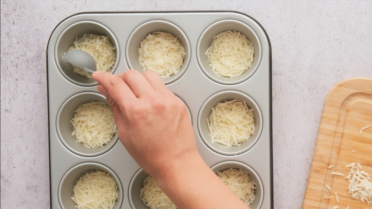 Putting grated parmesan cheese in muffin tin.
