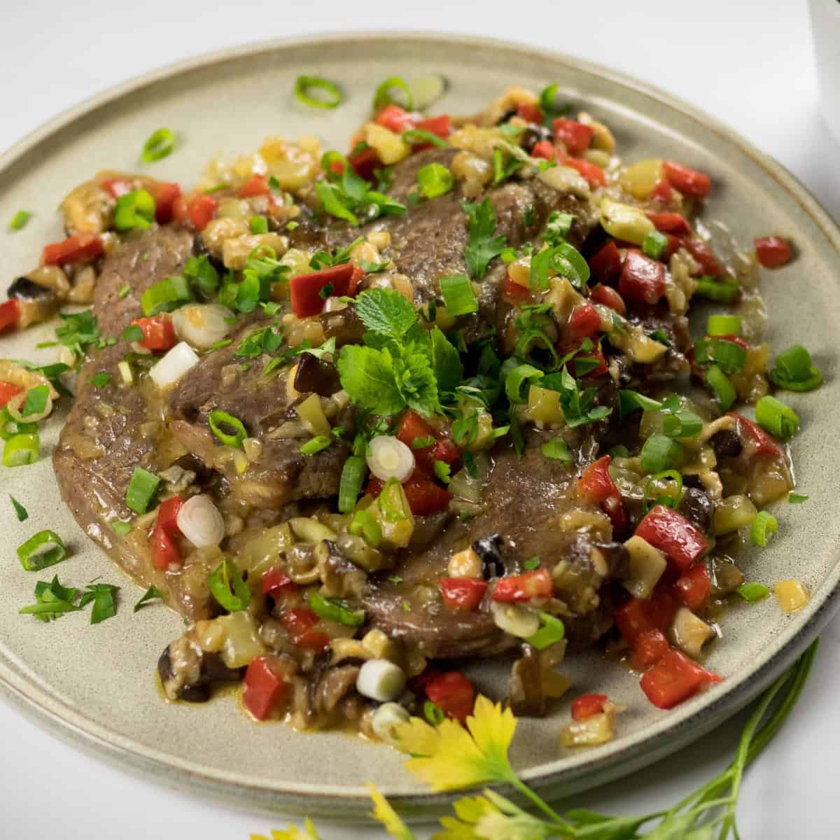 Keto Pepper Steak Recipe garnished with chopped green onions and served on a plate.