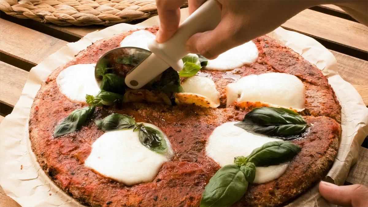 Slicing pizza with a pizza cutter.