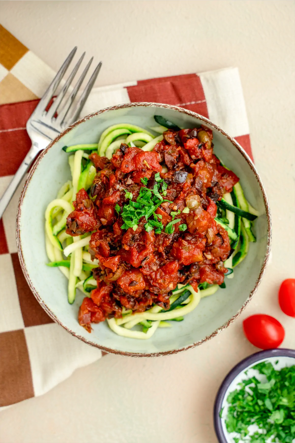 Keto tomato and anchovy based sauce and zucchini noodles served on a plate.