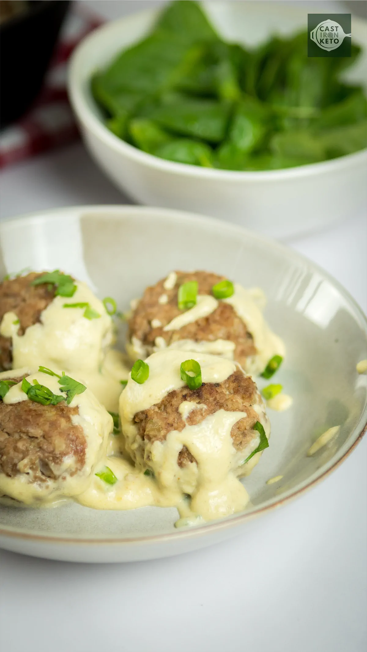 Swedish meatballs covered in creamy sauce on a plate.