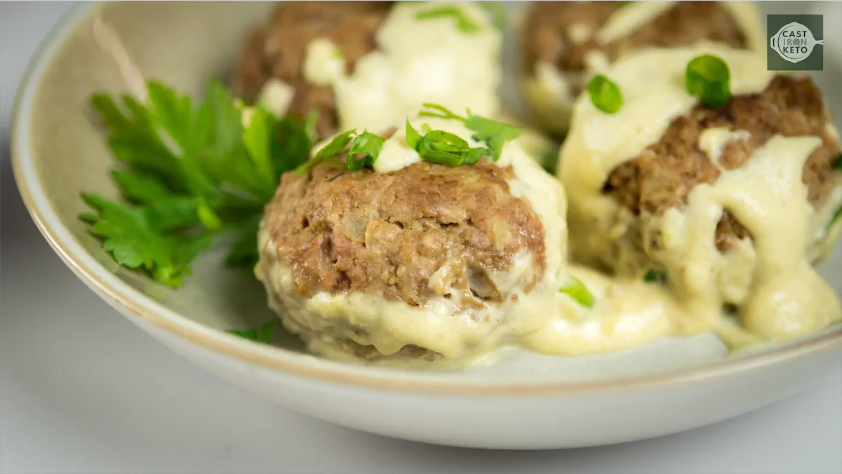 Keto meatball recipe with creamy sauce garnished with spring onions and coriander.