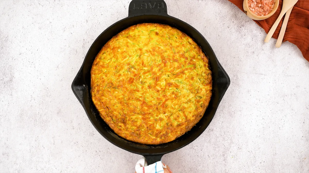 Fully baked low carb zucchini frittata recipe in a cast iron pan.