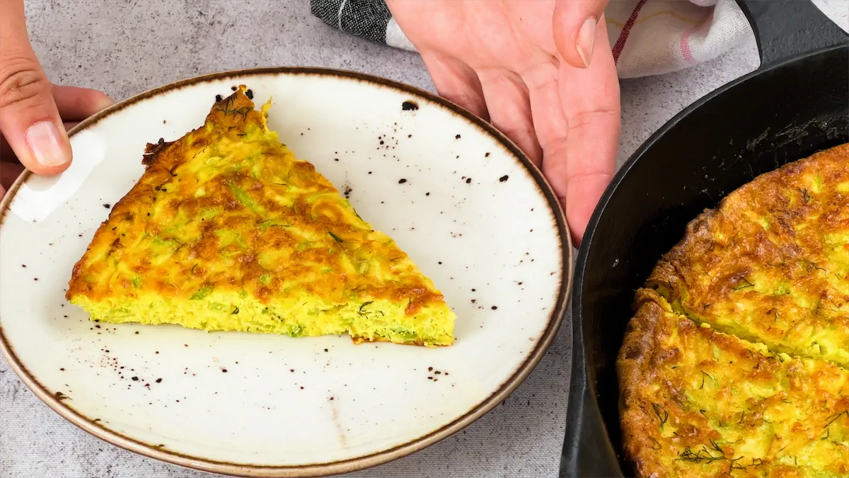 Slice of low carb zucchini frittata served on a white plate.