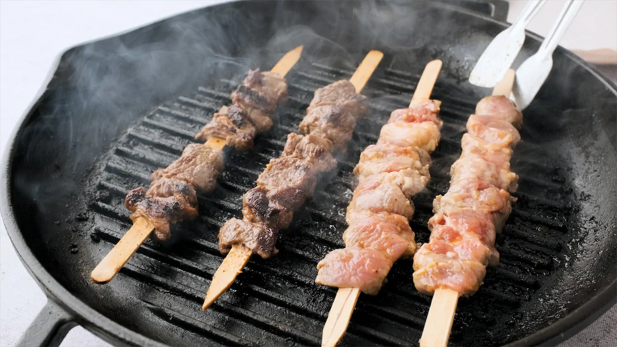 Grilling kebabs in a cast iron grill pan.