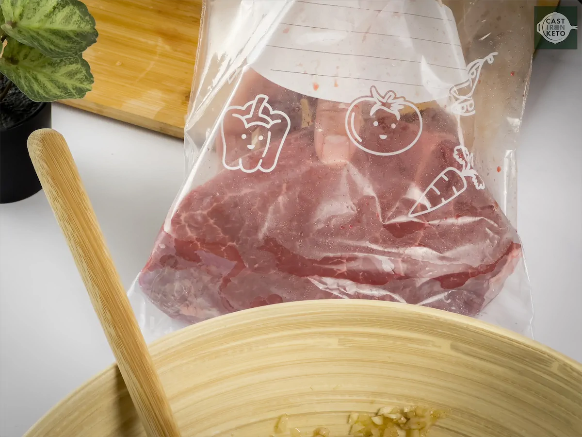 Putting London broil round steak slices in a sealable plastic bag.
