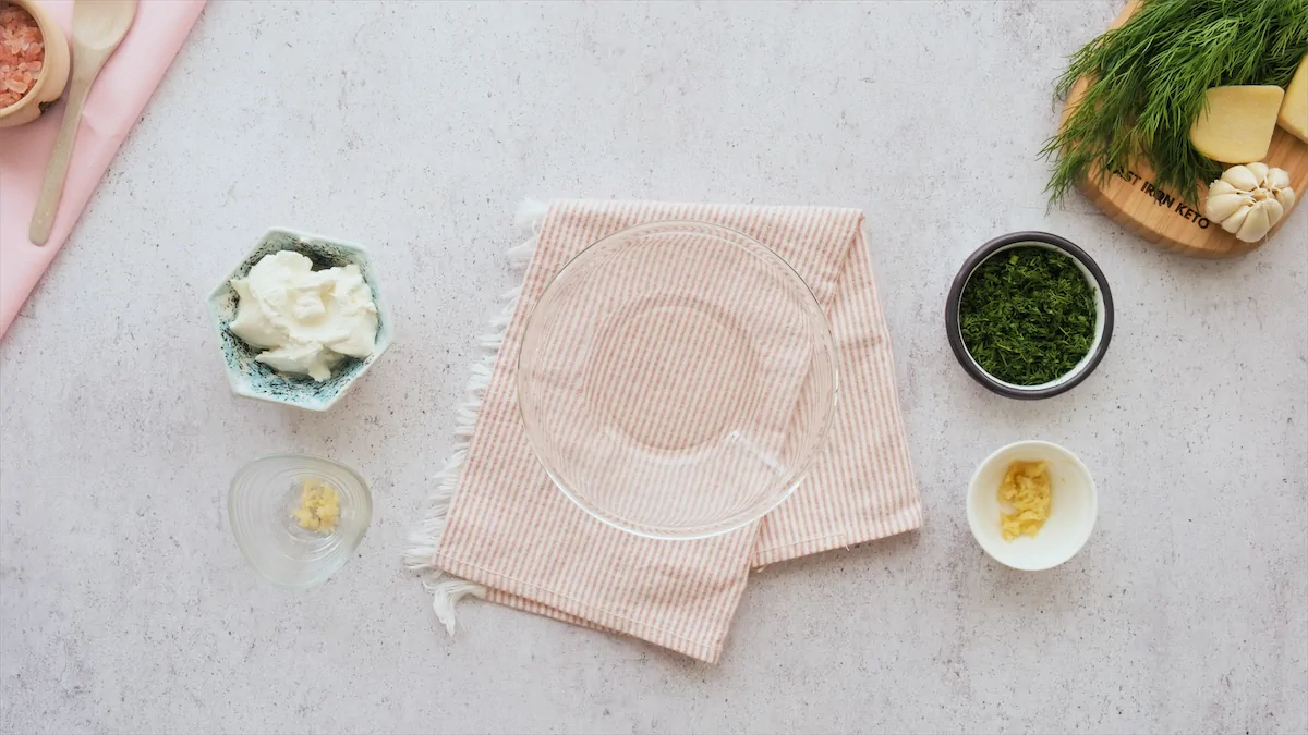 Ingredients like labneh, fresh dill, minced garlic, and zested ginger about to be mixed in a bowl.