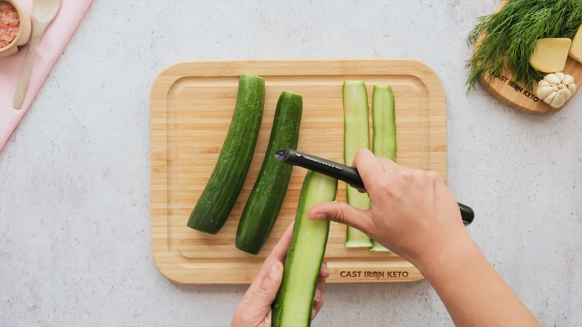 Peel the cucumbers vertically to create long, thin slices.