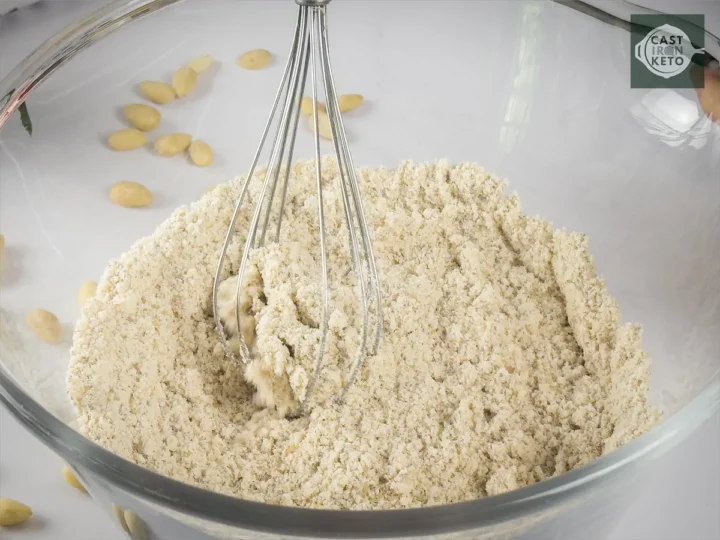 Whisking almond flour, brown Stevia, baking soda, and salt with a whisker in a large bowl.
