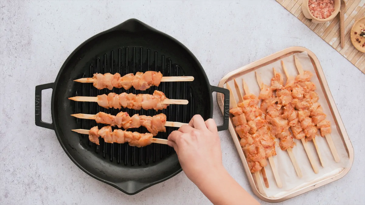 Grilling chicken skewers in a cast iron grill pan.