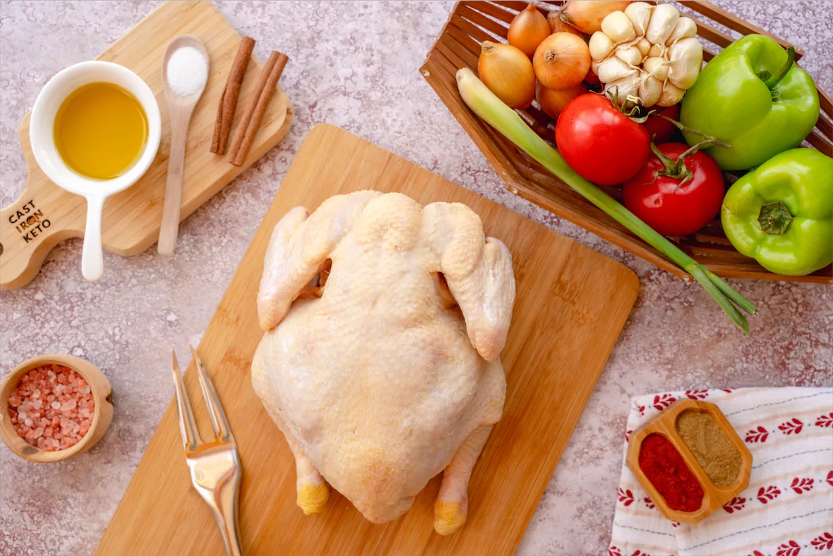 Ingredients made ready on kitchen table for the preparation of whole roasted chicken with vegetables recipe.