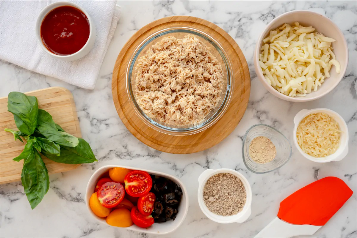 Ingredients prepared on the table to make keto pizza with chicken crust.