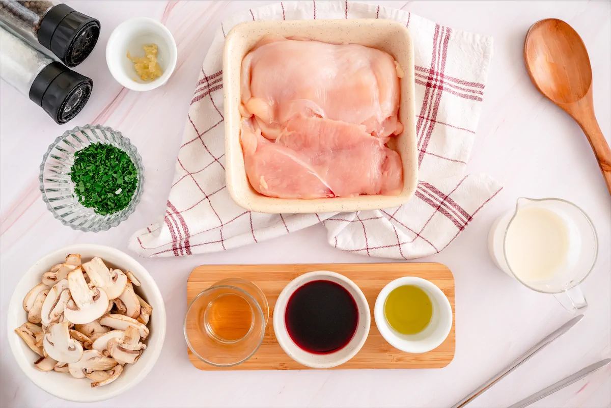 Ingredients made ready on kitchen table for the preparation of chicken marsala recipe.