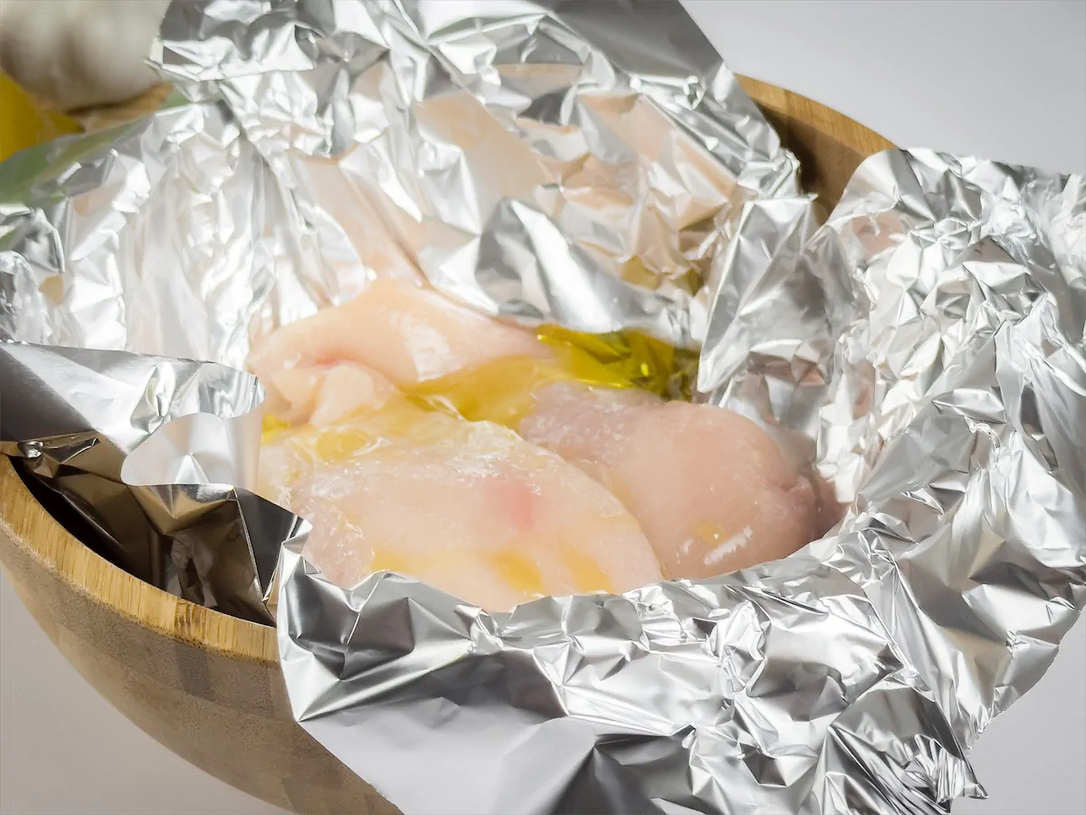 Chicken with lemon juice and a tablespoon of olive wrapped in aluminum foil.