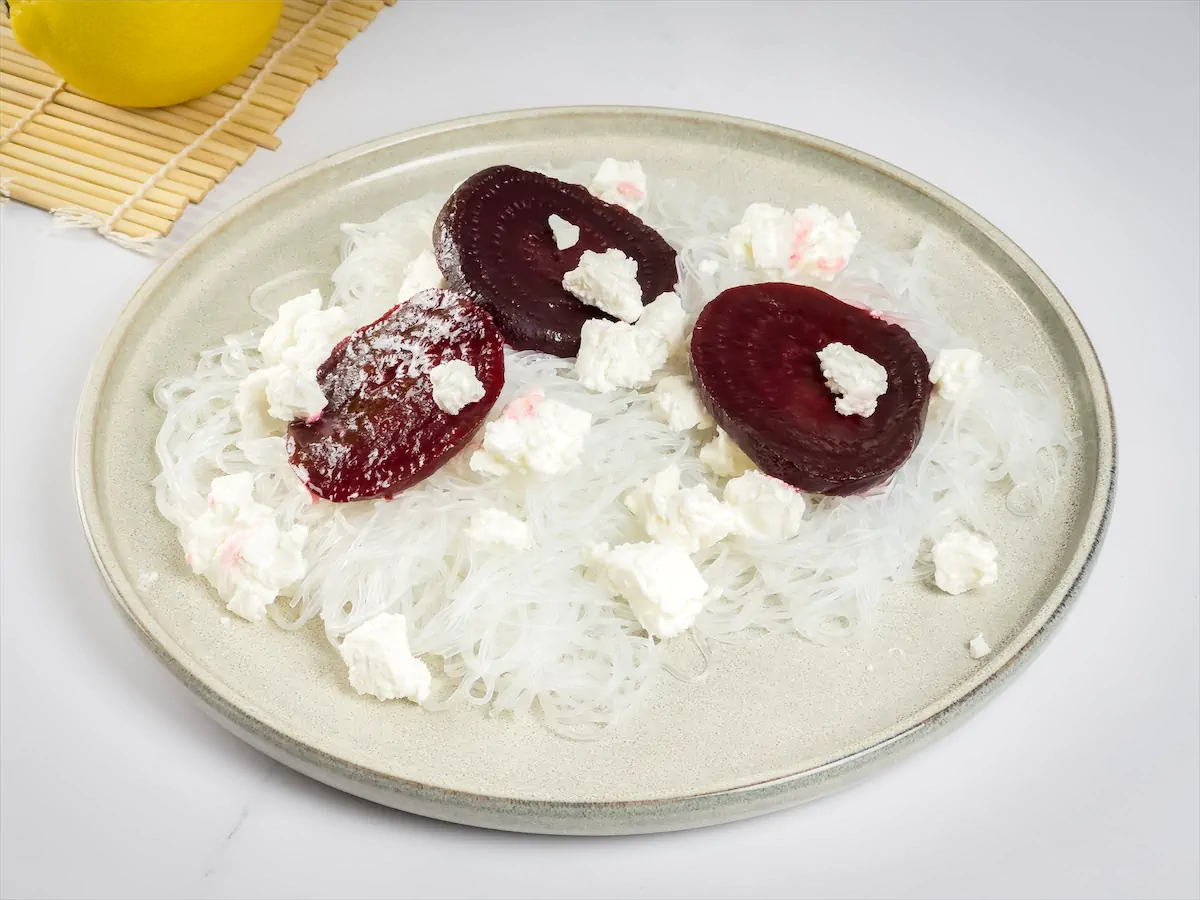 Beetroot, crumbled goat cheese, and konjac noodles on a plate.