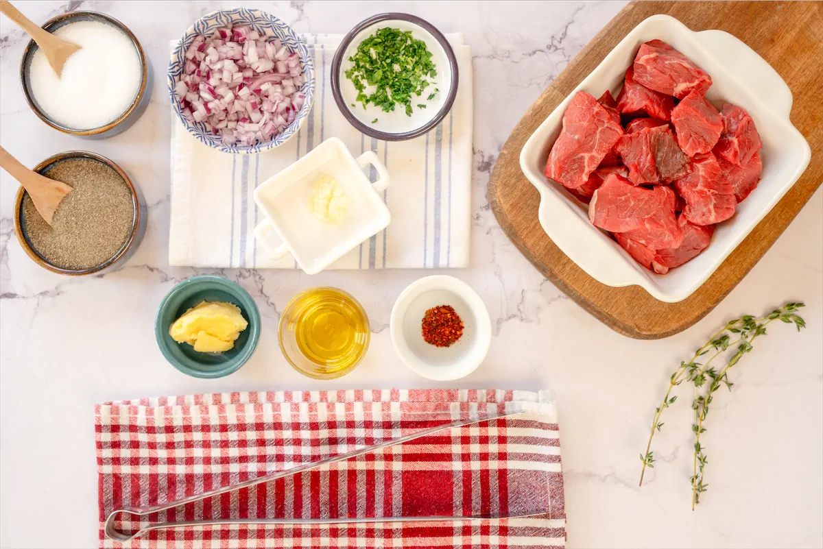 Ingredients made ready on kitchen table for the preparation of steak bites recipe.