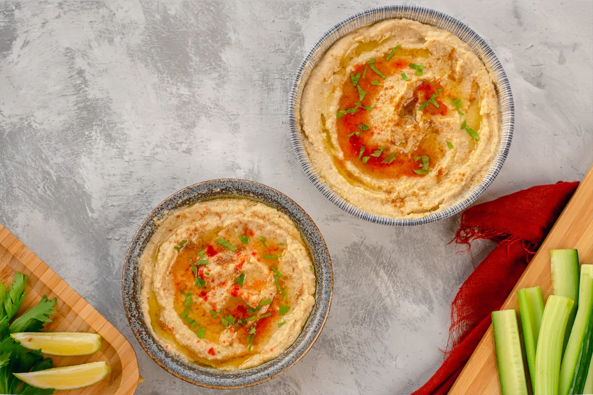 Bowls of hummus placed on kitchen table.
