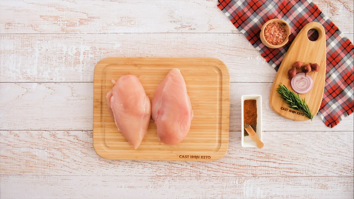 Chicken breasts on chopping board.