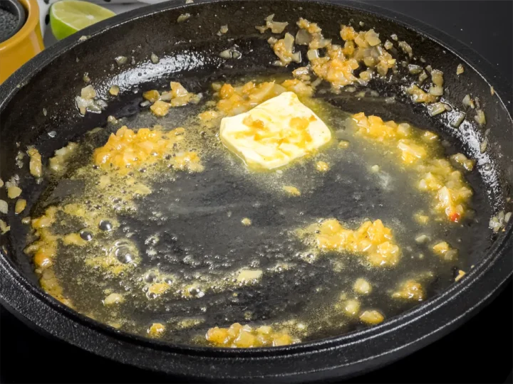 Butter melting in a cast iron skillet.