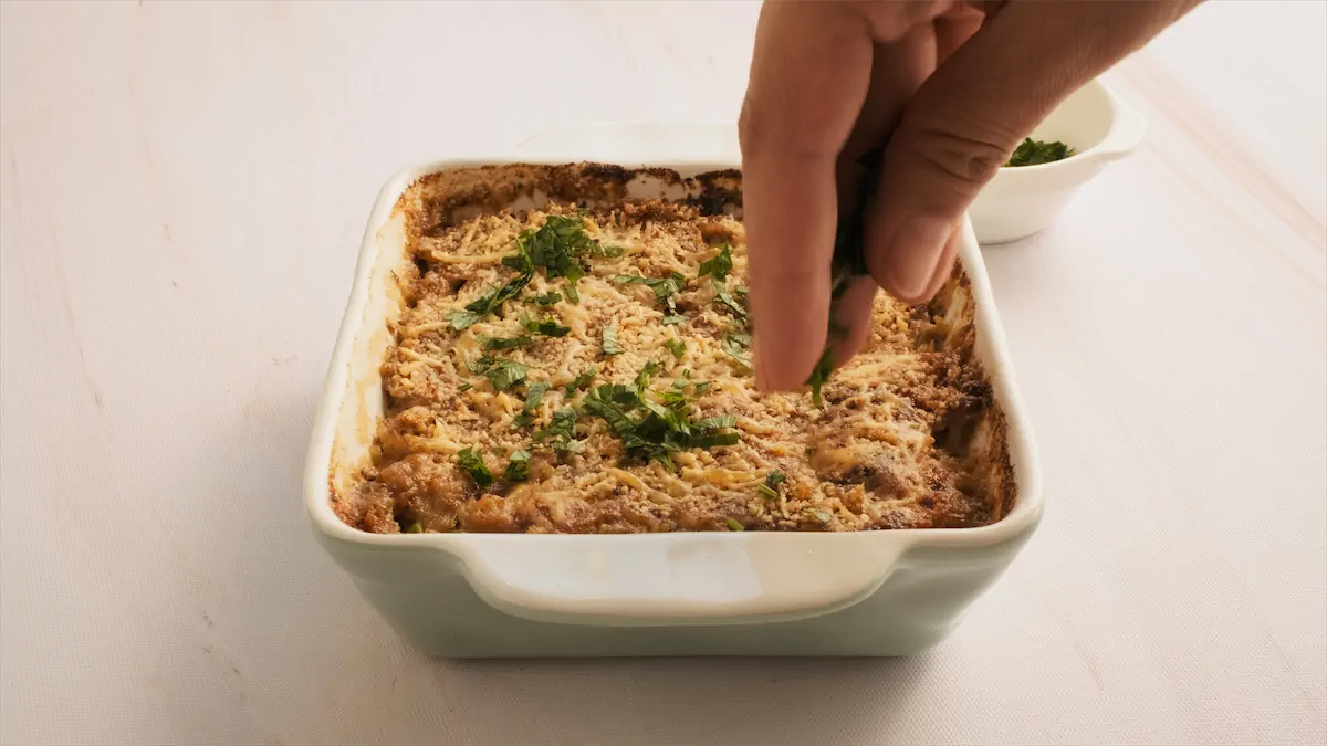 Topping the baked tuna casserole with fresh parsley.