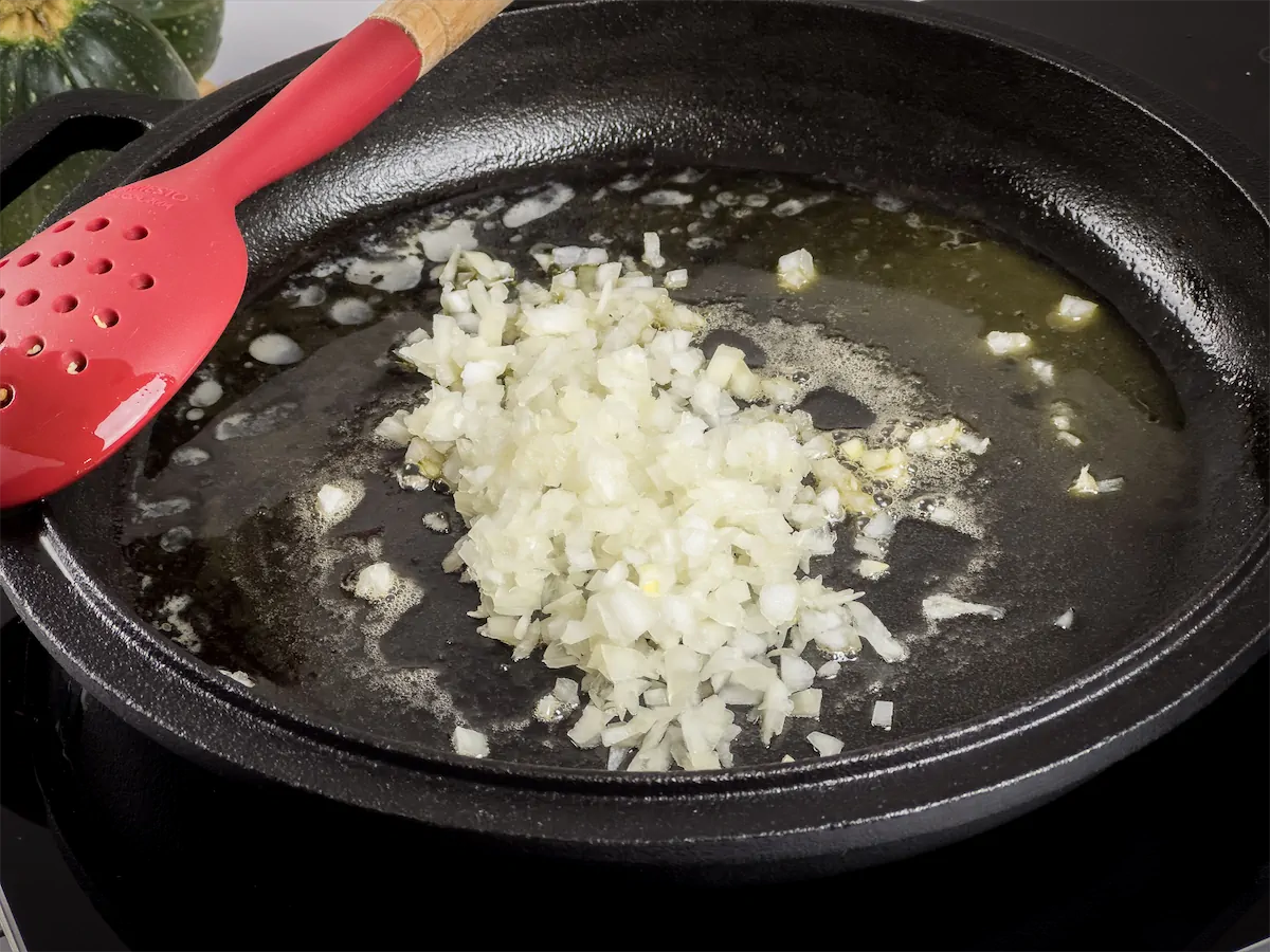 Adding diced onion to the skillet.