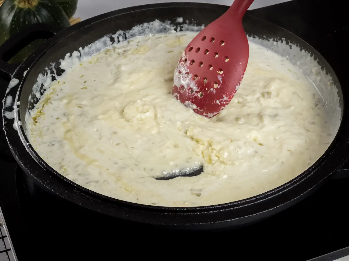 Cooking onions with heavy cream in a cast iron skillet.