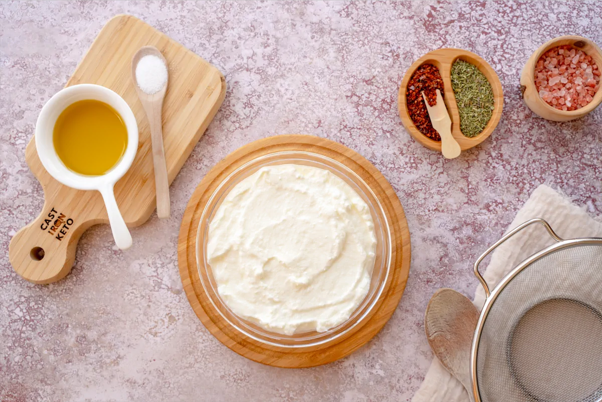 Ingredients like full-fat plain yogurt, sea salt, olive oil, herbs, chili flake made ready on the table for the preparation of Labneh.